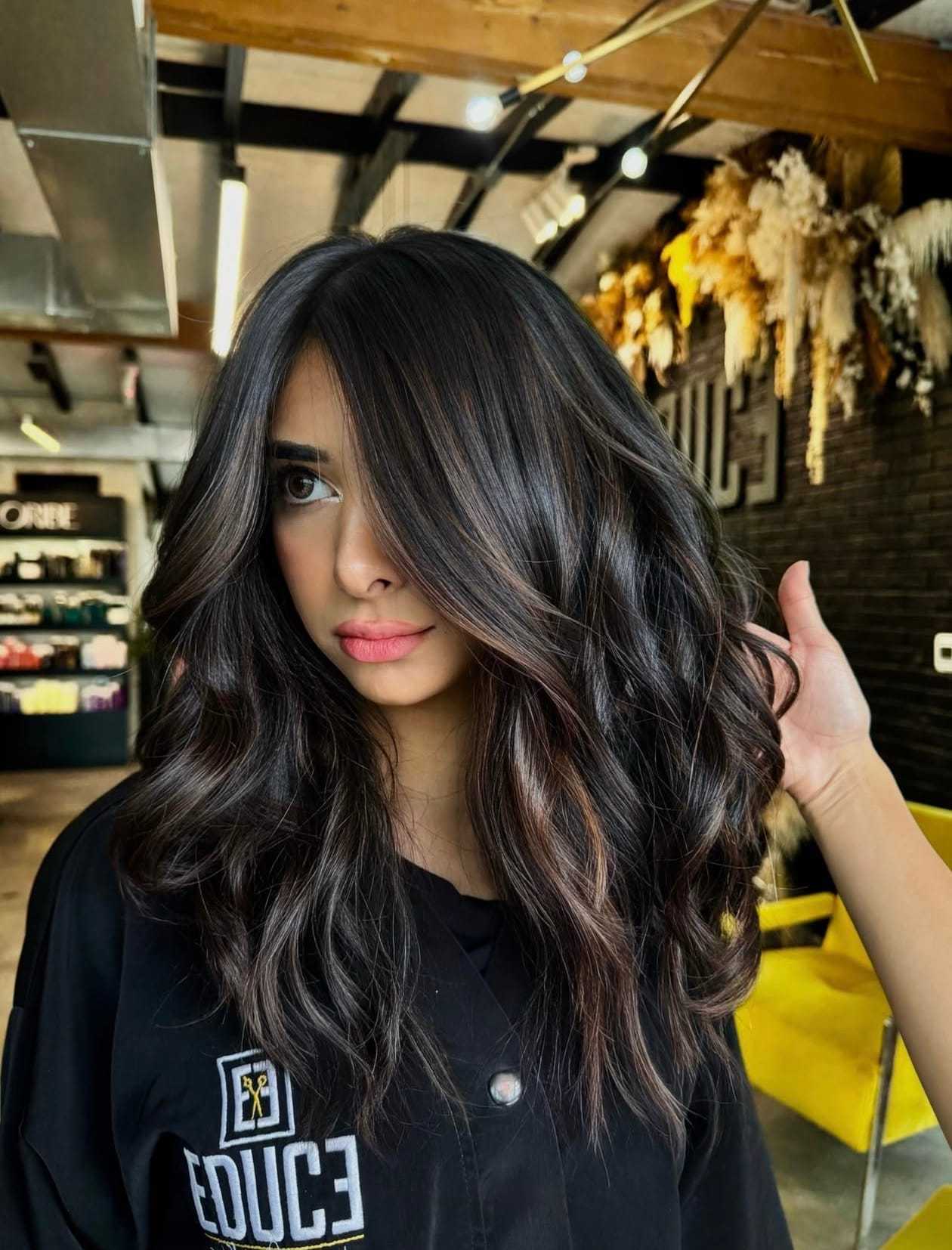 Person with wavy long hair in a modern salon.