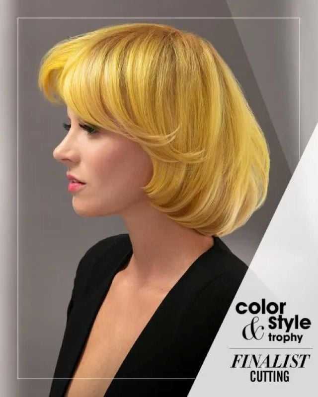 Woman with short yellow hair, black top; finalist in cutting category at hair styling event.